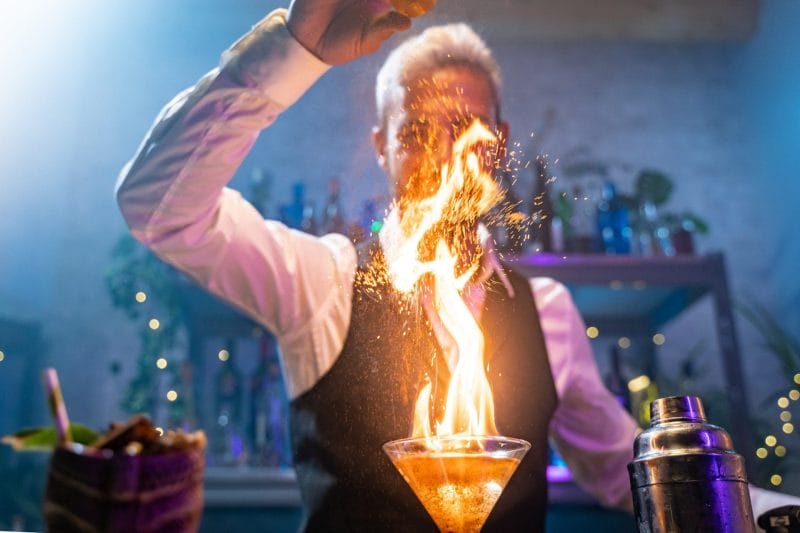 bartender making a cocktail with fire flame unique experience