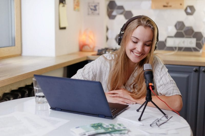 blonde woman wearing headphones with microphone learning online training class