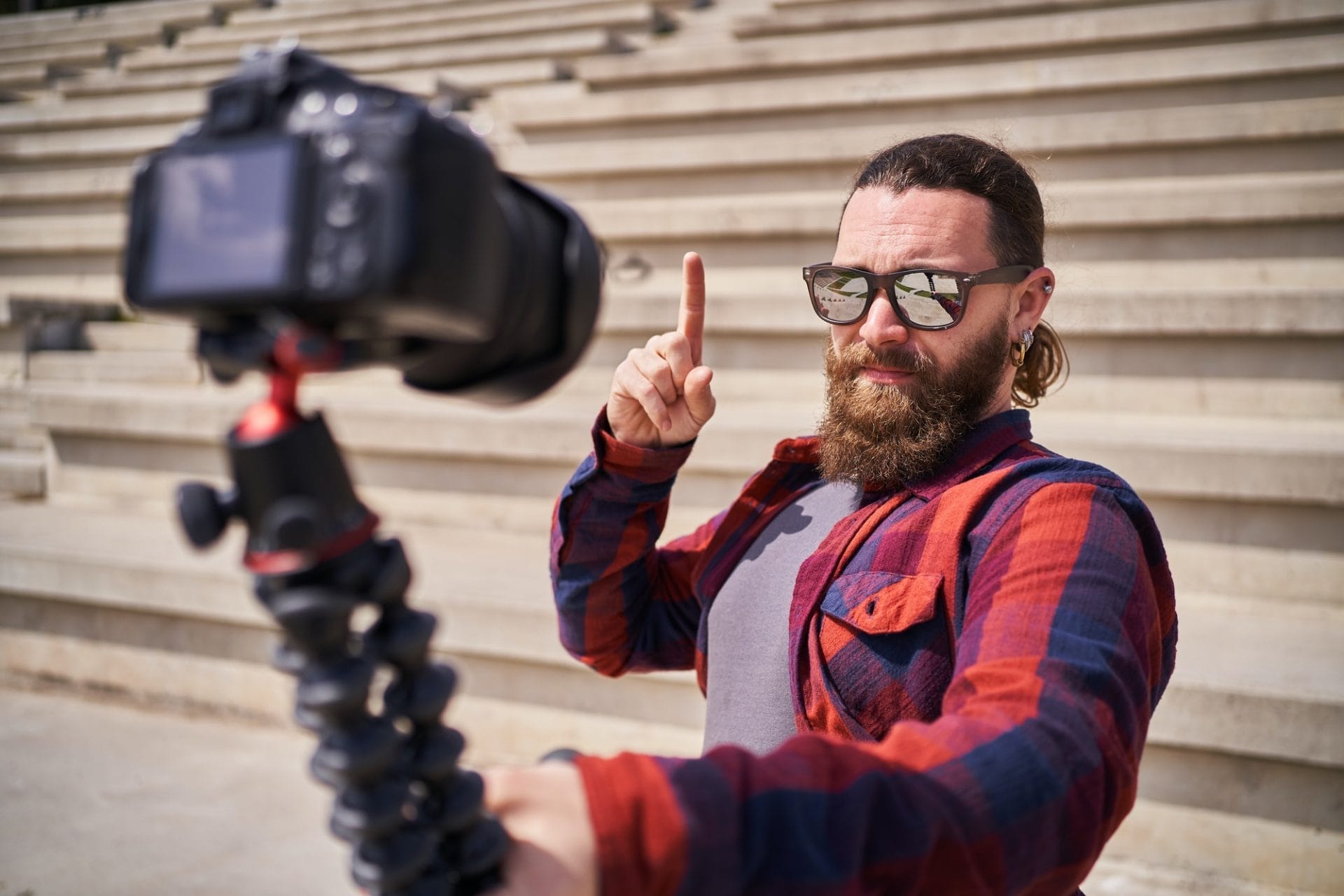 man with sunglasses recording with a camera while creating content for social media