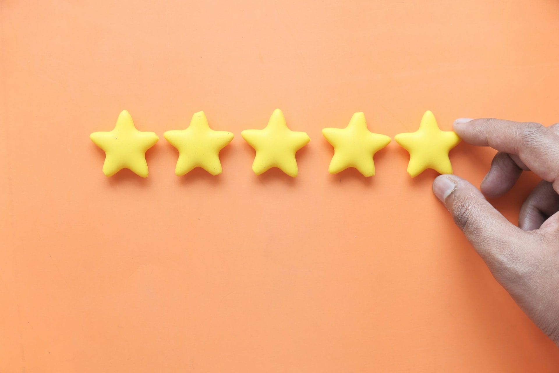 Customer review concept. Rating golden stars on orange background